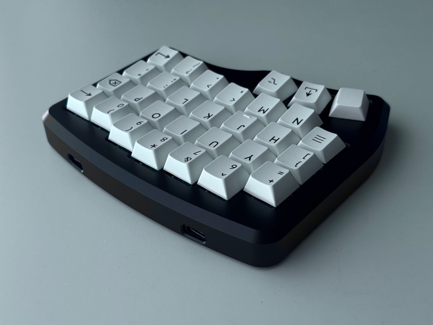 Back view of black Hall effect split keyboard with 4x6 column staggered keys and 3 thumb keys white keycaps