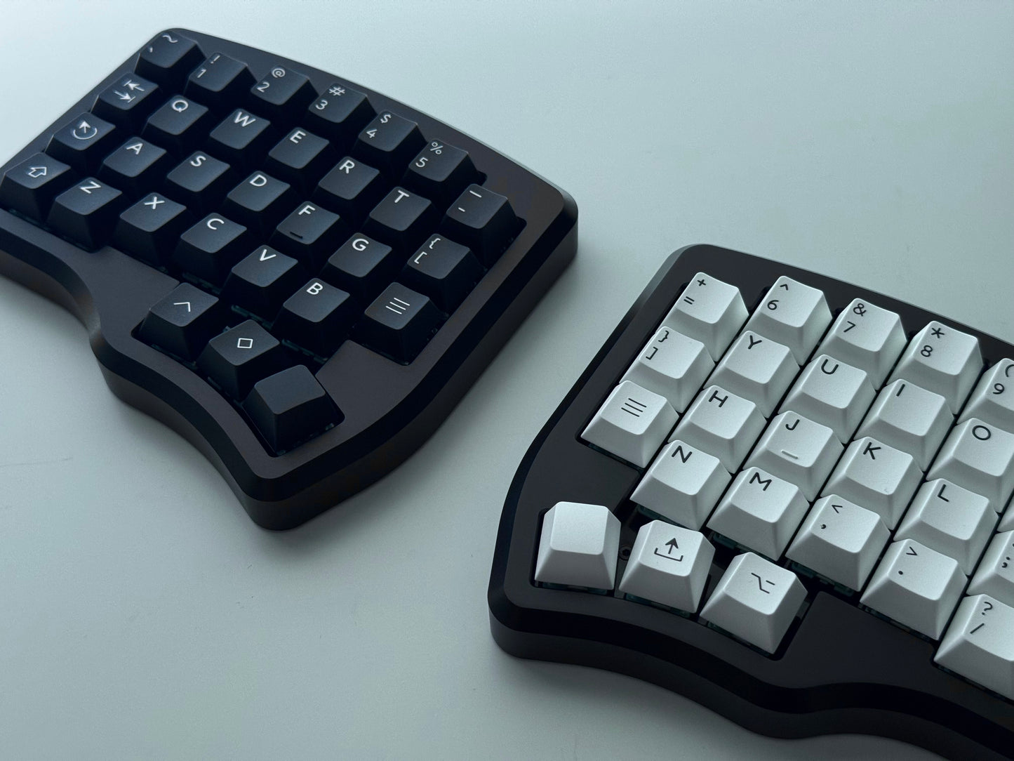 Black Hall effect split keyboard with 4x6 column staggered keys and 3 thumb keys black and white keycaps