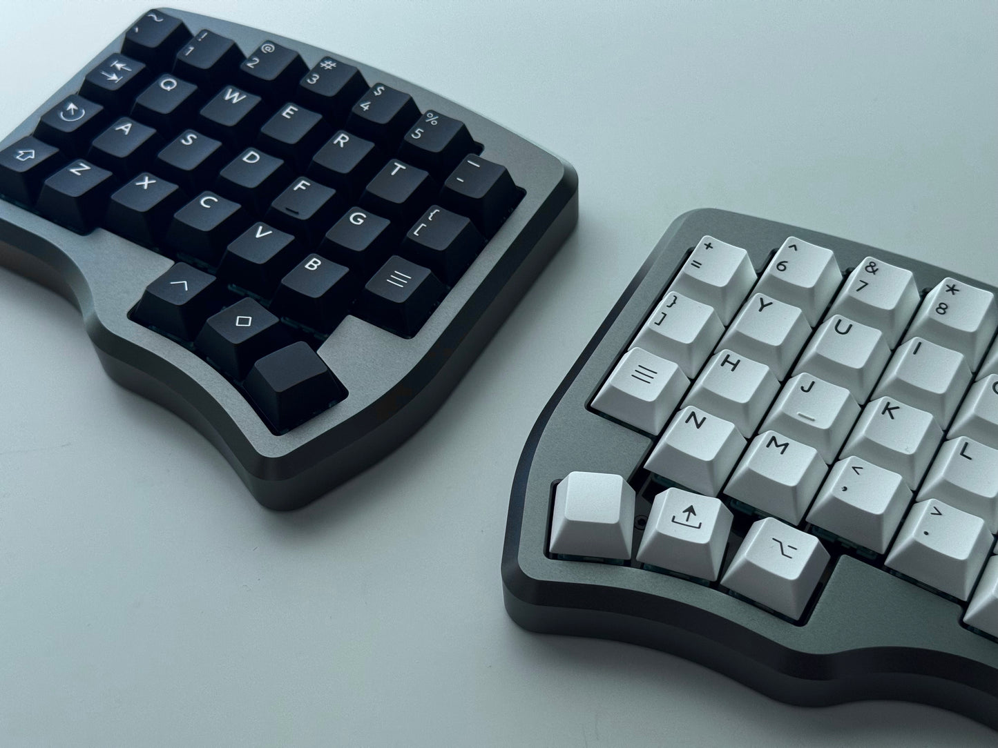 Grey Hall effect split keyboard with 4x6 column staggered keys and 3 thumb keys black and white keycaps