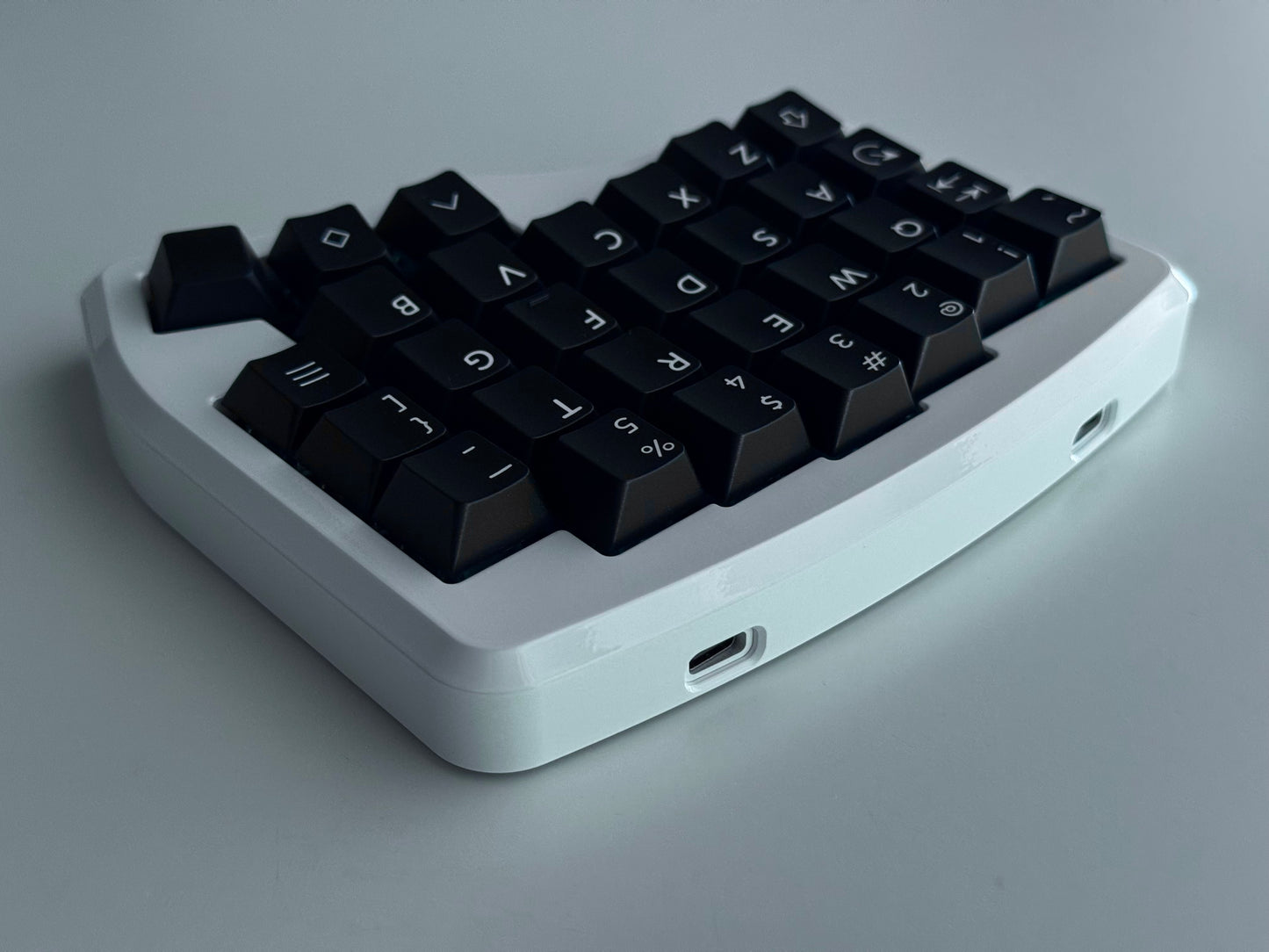 Back view of white Hall effect split keyboard with 4x6 column staggered keys and 3 thumb keys black keycaps