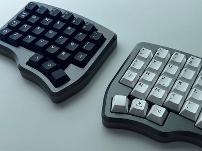 Grey Hall effect split keyboard with 4x6 column staggered keys and 3 thumb keys black and white keycaps