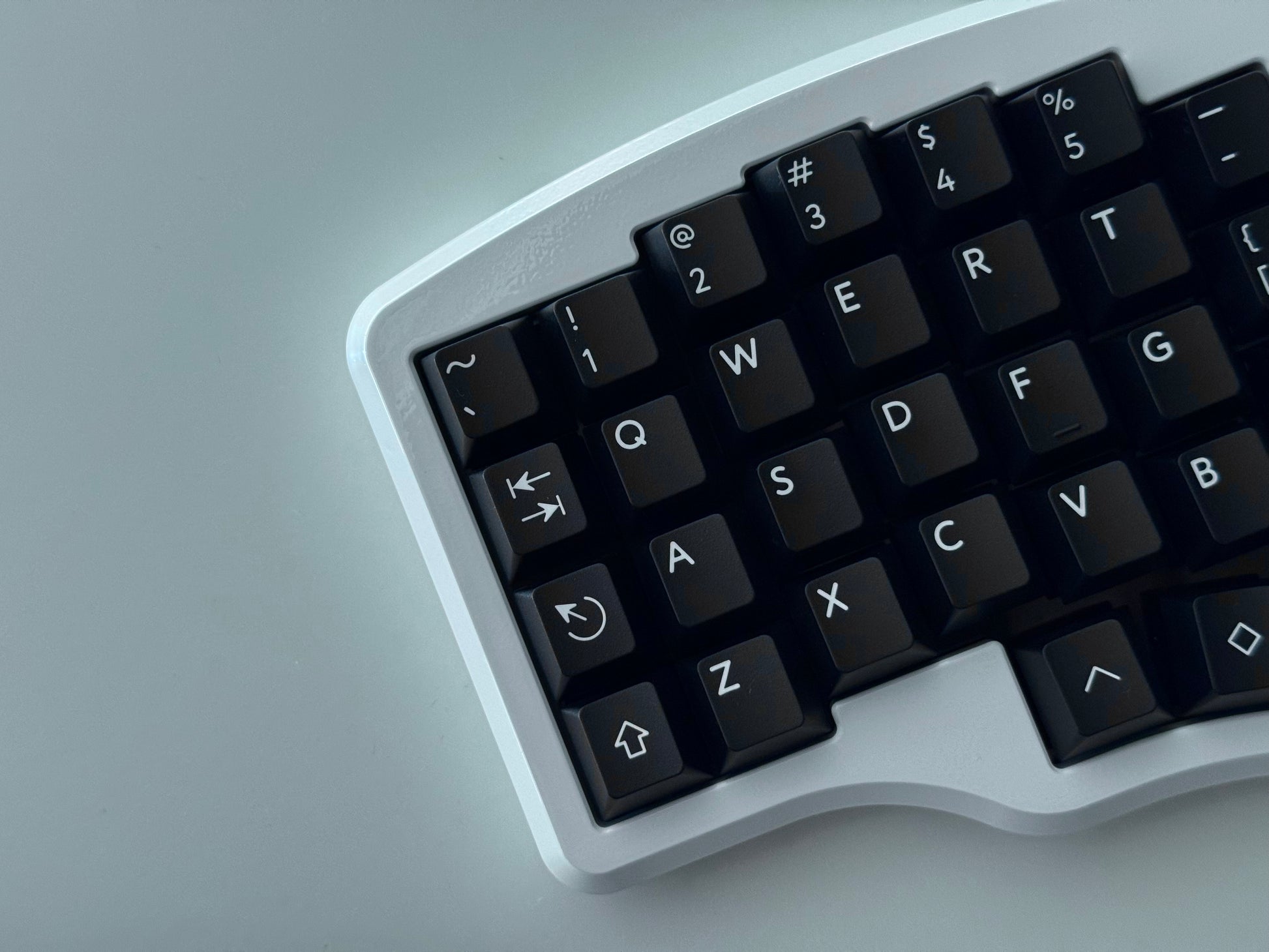 Top view of white Hall effect split keyboard with 4x6 column staggered keys and 3 thumb keys black keycaps