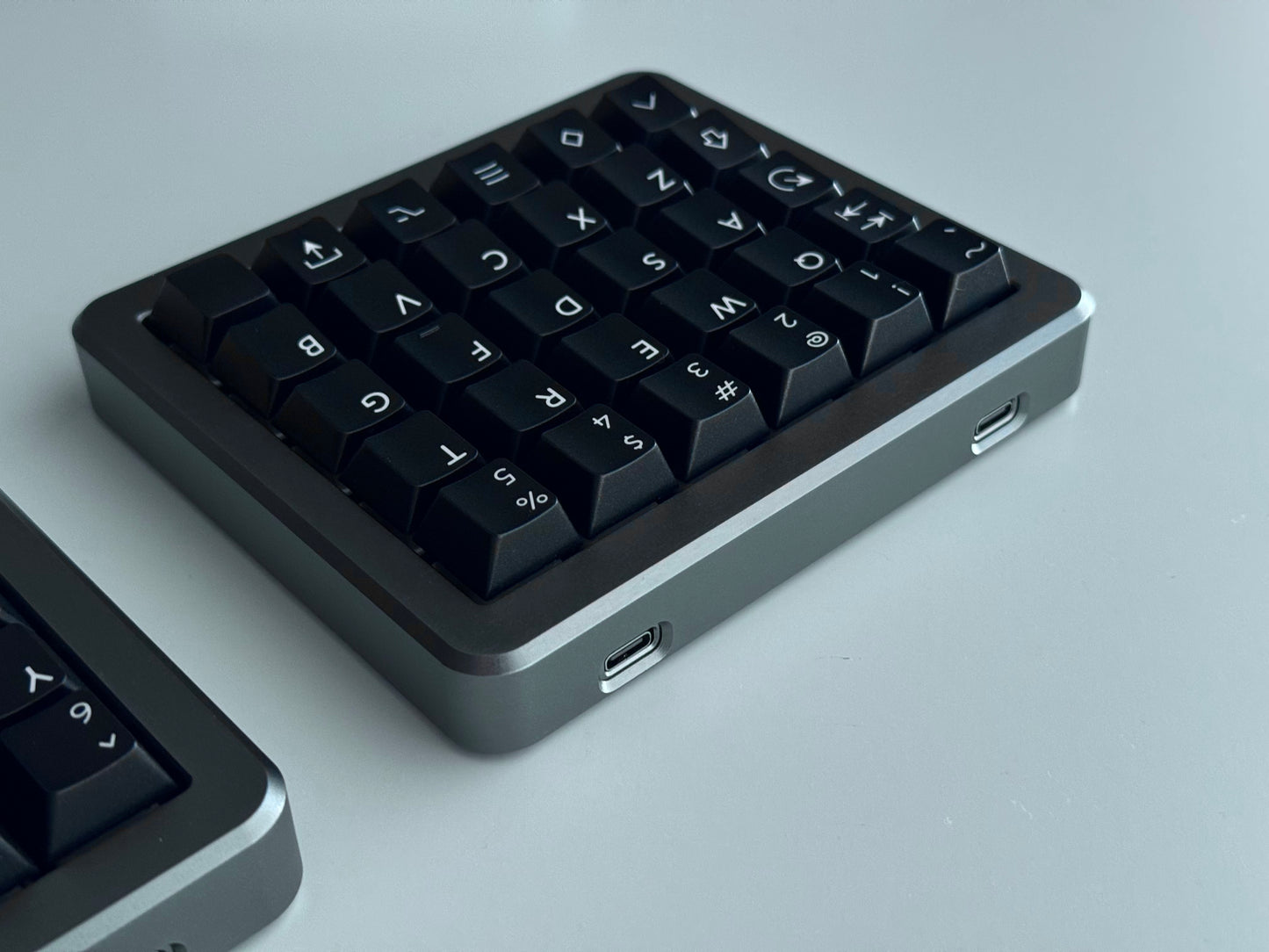 Back view of grey Hall effect split keyboard 5x6 ortholinear with black keycaps