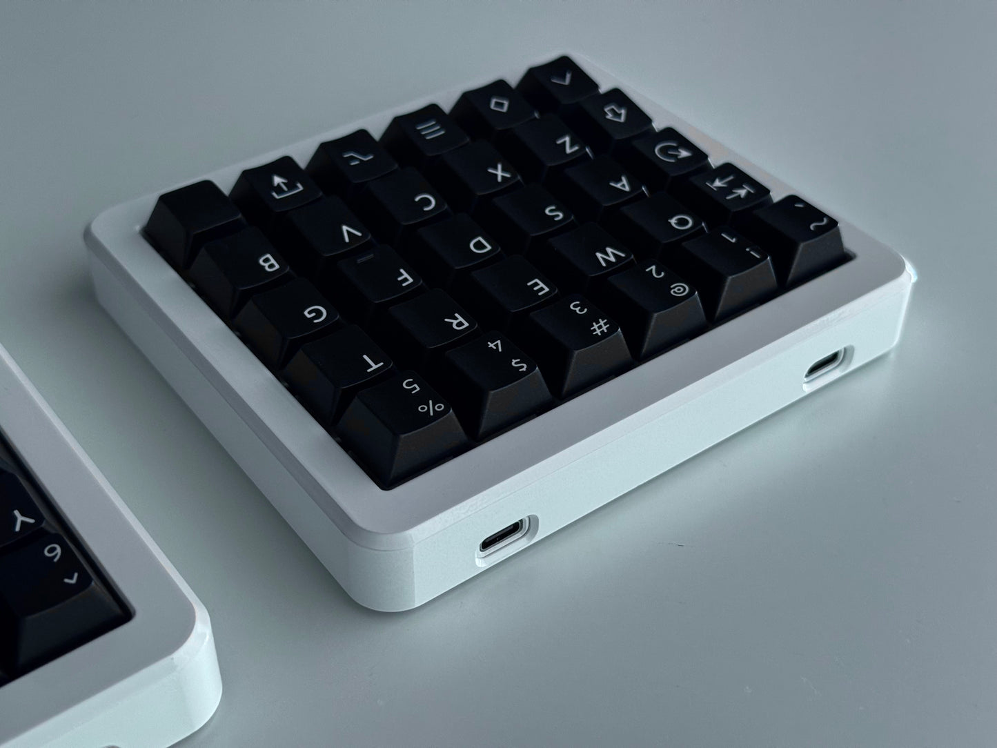 Back view of white Hall effect split keyboard 5x6 ortholinear with black keycaps